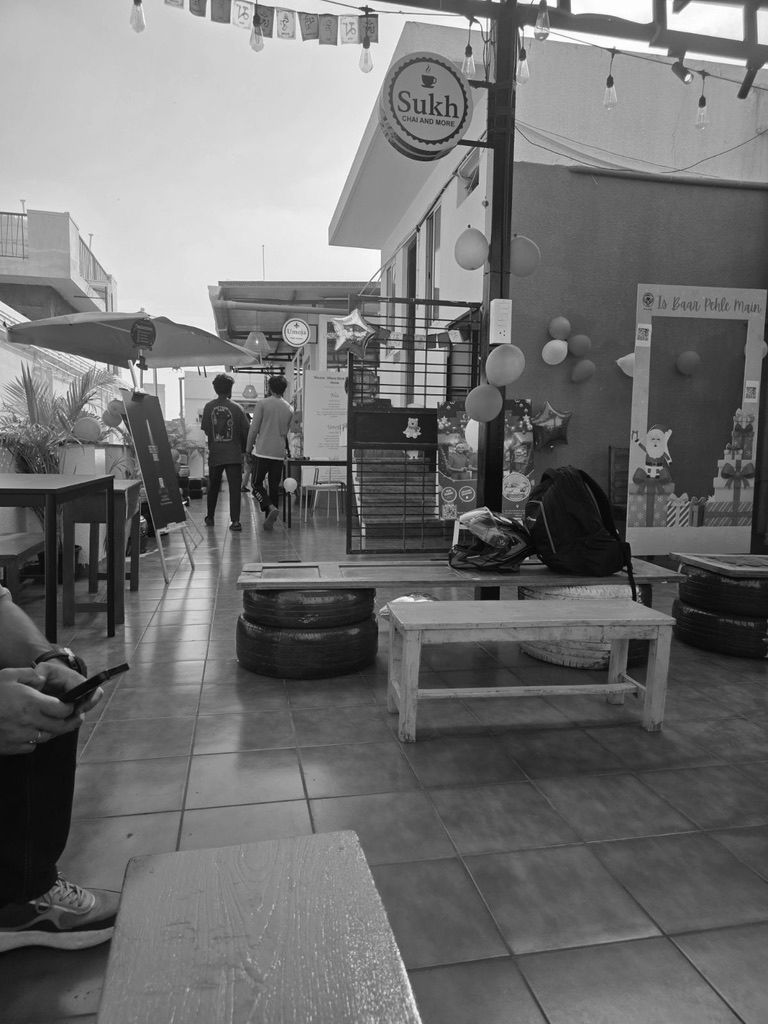 A rooftop commons at a Nia residence with an on-site café, seating and members, where local sellers serve the community