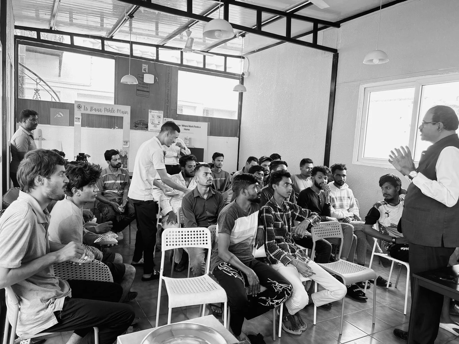 Nia members gathered in a residence common room, listening to a speaker over shared snacks