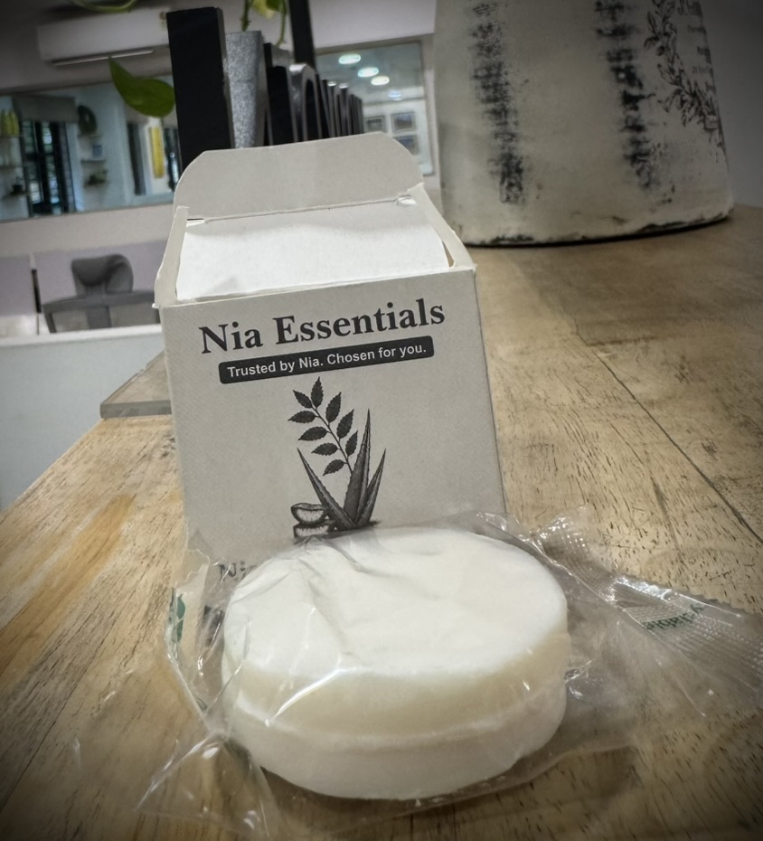 A Nia Essentials branded box reading 'Trusted by Nia. Chosen for you.' with a wrapped soap bar, products built for members