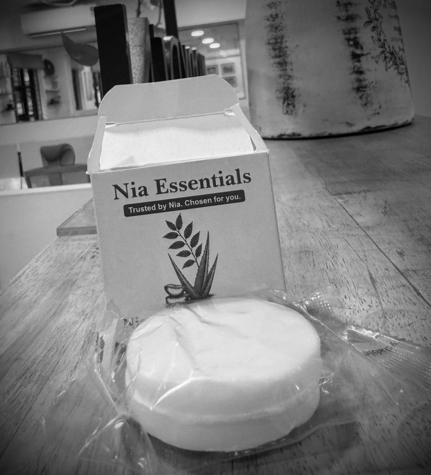A Nia Essentials branded box reading 'Trusted by Nia. Chosen for you.' with a wrapped soap bar, products built for members